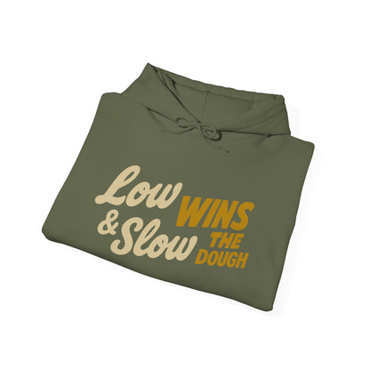 Folded green hoodie with text 'Low & Slow Wins The Dough' on a white background