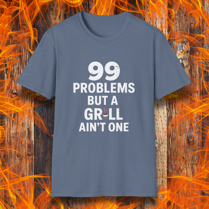 Heather Indigo T-shirt with bold white text that says "99 Problems But a Grill Ain’t One," featuring a small red grill icon replacing the "I" in "Grill" — a playful shirt for BBQ fans and grilling pros.