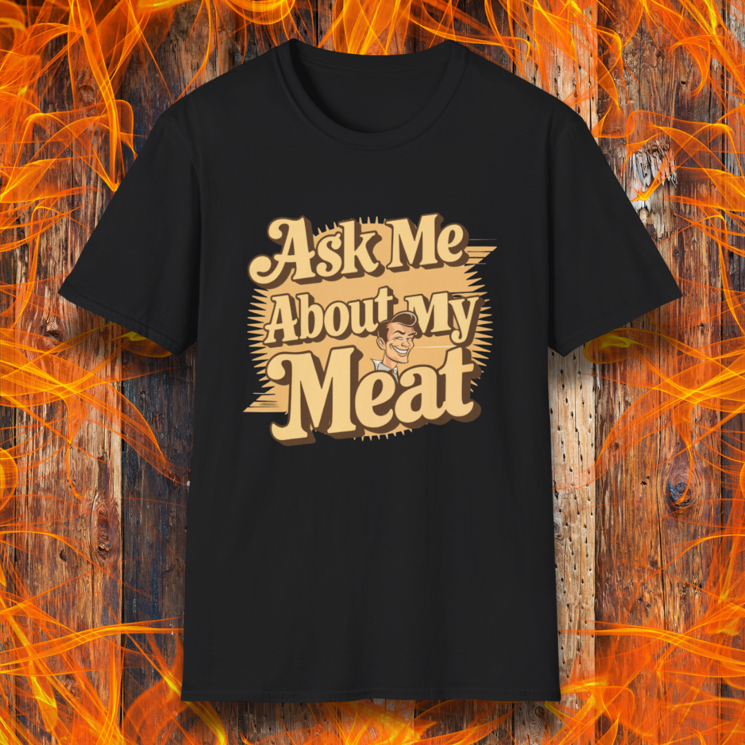 Black T-shirt featuring a retro-style design with the phrase 'Ask Me About My Meat' in bold, vintage lettering. The text is accented with a smiling, cartoon-style character, giving it a humorous and playful BBQ-themed vibe.