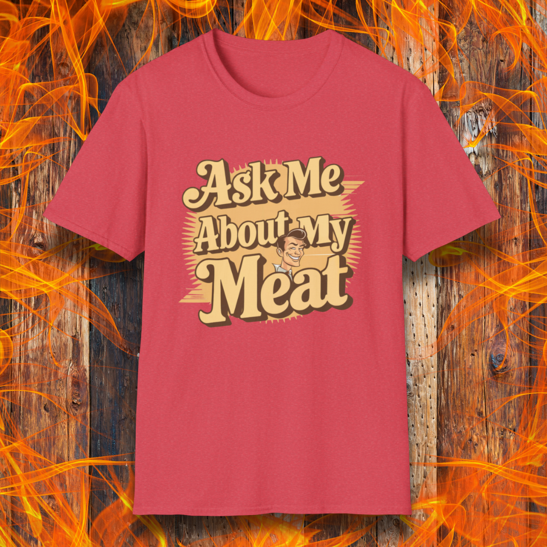 Heather Red T-shirt featuring a retro-style design with the phrase 'Ask Me About My Meat' in bold, vintage lettering. The text is accented with a smiling, cartoon-style character, giving it a humorous and playful BBQ-themed vibe.