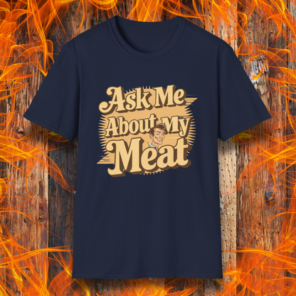 Navy T-shirt featuring a retro-style design with the phrase 'Ask Me About My Meat' in bold, vintage lettering. The text is accented with a smiling, cartoon-style character, giving it a humorous and playful BBQ-themed vibe.