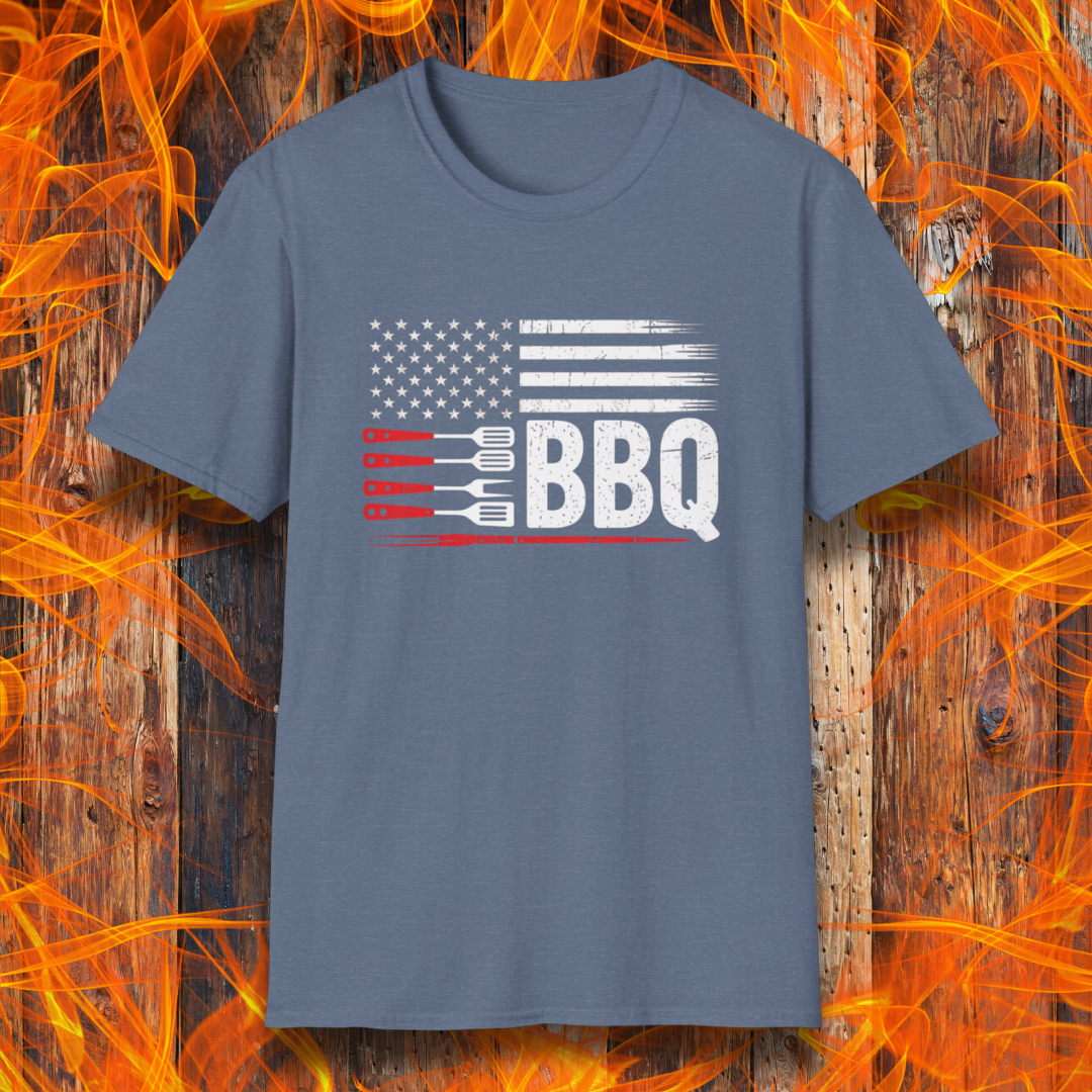 Blue t-shirt with American flag and BBQ graphic on a wooden background with flames.