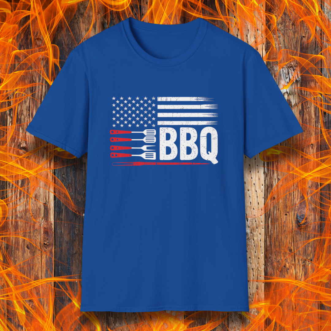 Blue t-shirt with American flag and BBQ graphic on a wooden background with flames.