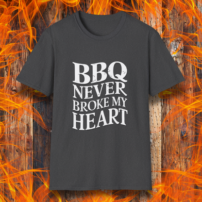 Dark Heather  t-shirt featuring bold white text that reads 'BBQ Never Broke My Heart' in a rustic, slightly distressed font, perfect for barbecue lovers who stay loyal to great smoked meats.