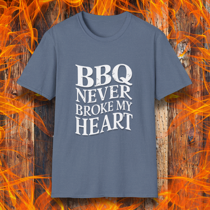 Heather Indigo  t-shirt featuring bold white text that reads 'BBQ Never Broke My Heart' in a rustic, slightly distressed font, perfect for barbecue lovers who stay loyal to great smoked meats.
