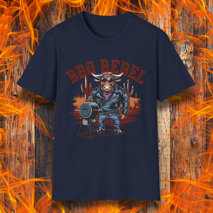 Navy T-shirt featuring a bold and rebellious BBQ-themed design. The centerpiece is an anthropomorphic bull dressed like a biker, wearing a black leather jacket, blue jeans, and a red bandana, exuding a tough and confident attitude. He stands next to a classic barrel-style smoker. The background includes red flames and grill forks, adding to the edgy, fiery vibe. Above the character, "BBQ REBEL" is displayed in bold, vintage-style red lettering.  