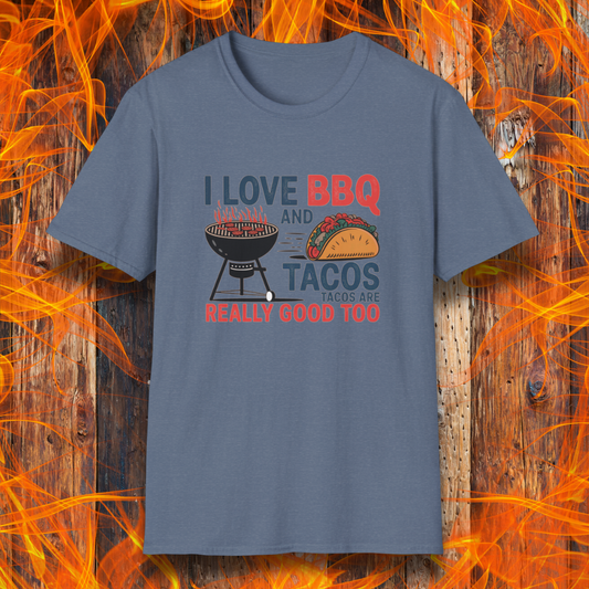 Heather Indigo T-shirt features a fun and bold design that reads, "I Love BBQ and Tacos... Tacos Are Really Good Too," with graphics of a flaming grill and a delicious taco. Perfect for BBQ lovers who also enjoy a good taco, this shirt combines humor and food passion in a stylish way.