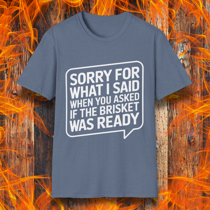 Heather Indigo T-shirt with bold white text inside a speech bubble that reads, "Sorry for what I said when you asked if the brisket was ready." A fun and relatable design for BBQ lovers and pitmasters.