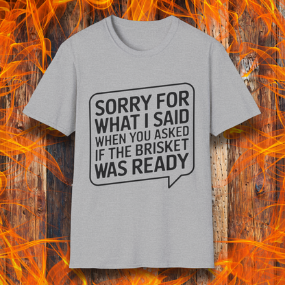 Sport Grey T-shirt with bold white text inside a speech bubble that reads, "Sorry for what I said when you asked if the brisket was ready." A fun and relatable design for BBQ lovers and pitmasters.