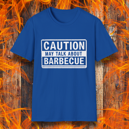 Royal Blue T-shirt featuring a bold, high-contrast design resembling a caution sign. The text reads 'CAUTION MAY TALK ABOUT BARBECUE' in white, with a distressed effect, making it perfect for BBQ enthusiasts who love to chat about grilling.