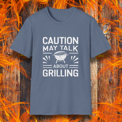 Heather Indigo T-shirt featuring bold white text that reads 'CAUTION MAY TALK ABOUT GRILLING,' with a vintage-style BBQ grill illustration and decorative lines. Perfect for passionate grill masters who can't stop talking about barbecue.