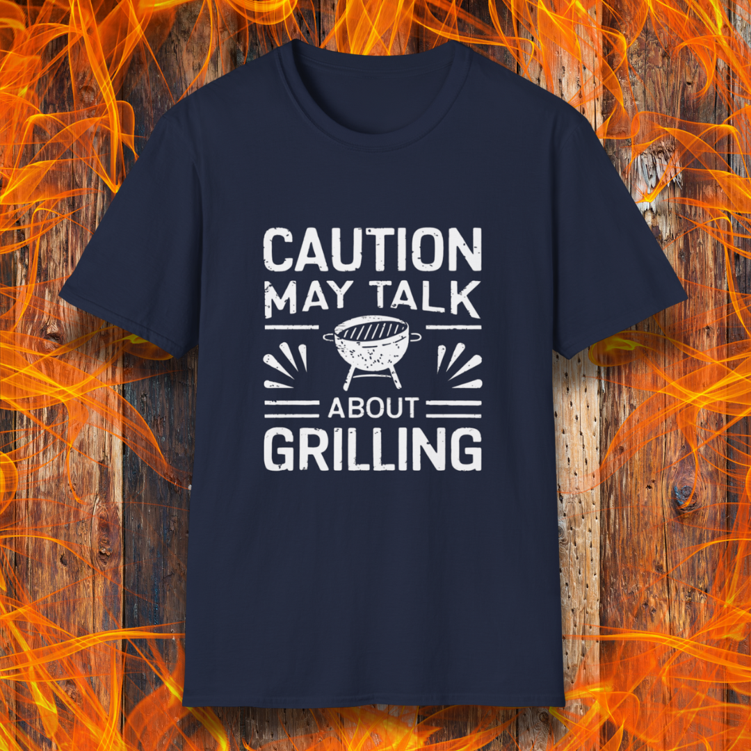 Navy T-shirt featuring bold white text that reads 'CAUTION MAY TALK ABOUT GRILLING,' with a vintage-style BBQ grill illustration and decorative lines. Perfect for passionate grill masters who can't stop talking about barbecue.