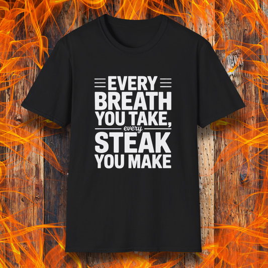 Black T-shirt with bold white text that reads "Every Breath You Take, Every Steak You Make," displayed over a rustic wood and flame background — a humorous grilling shirt perfect for steak fans.