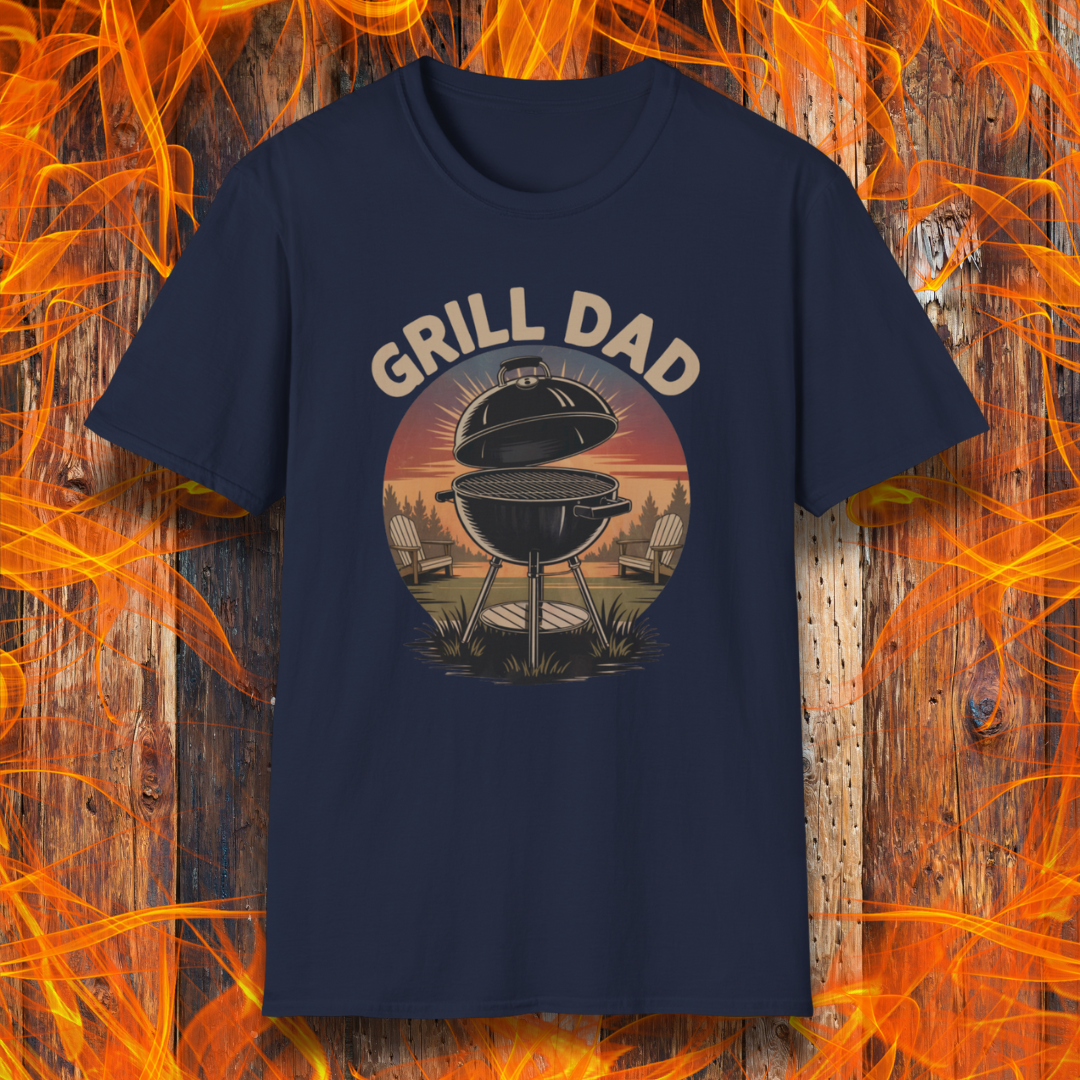 Navy blue t-shirt with 'Grill Dad' graphic on a wooden background with flames.