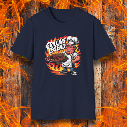 Navy t-shirt featuring a cartoon-style chef character holding a platter of perfectly grilled meats, with flames in the background and bold text that reads 'Grilling Legend'—ideal for BBQ masters and pit bosses