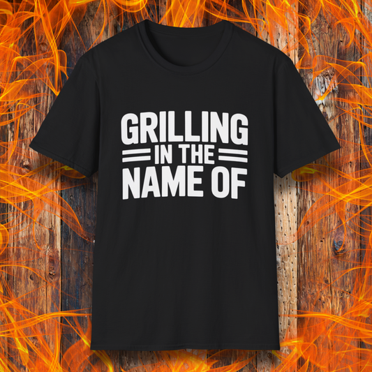 Black T-shirt with bold white text that reads "Grilling in the Name Of" in a stacked, block-style font — a humorous BBQ-themed shirt for grilling enthusiasts.