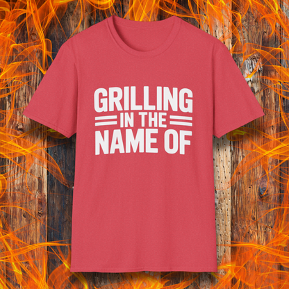 Heather Red T-shirt with bold white text that reads "Grilling in the Name Of" in a stacked, block-style font — a humorous BBQ-themed shirt for grilling enthusiasts.