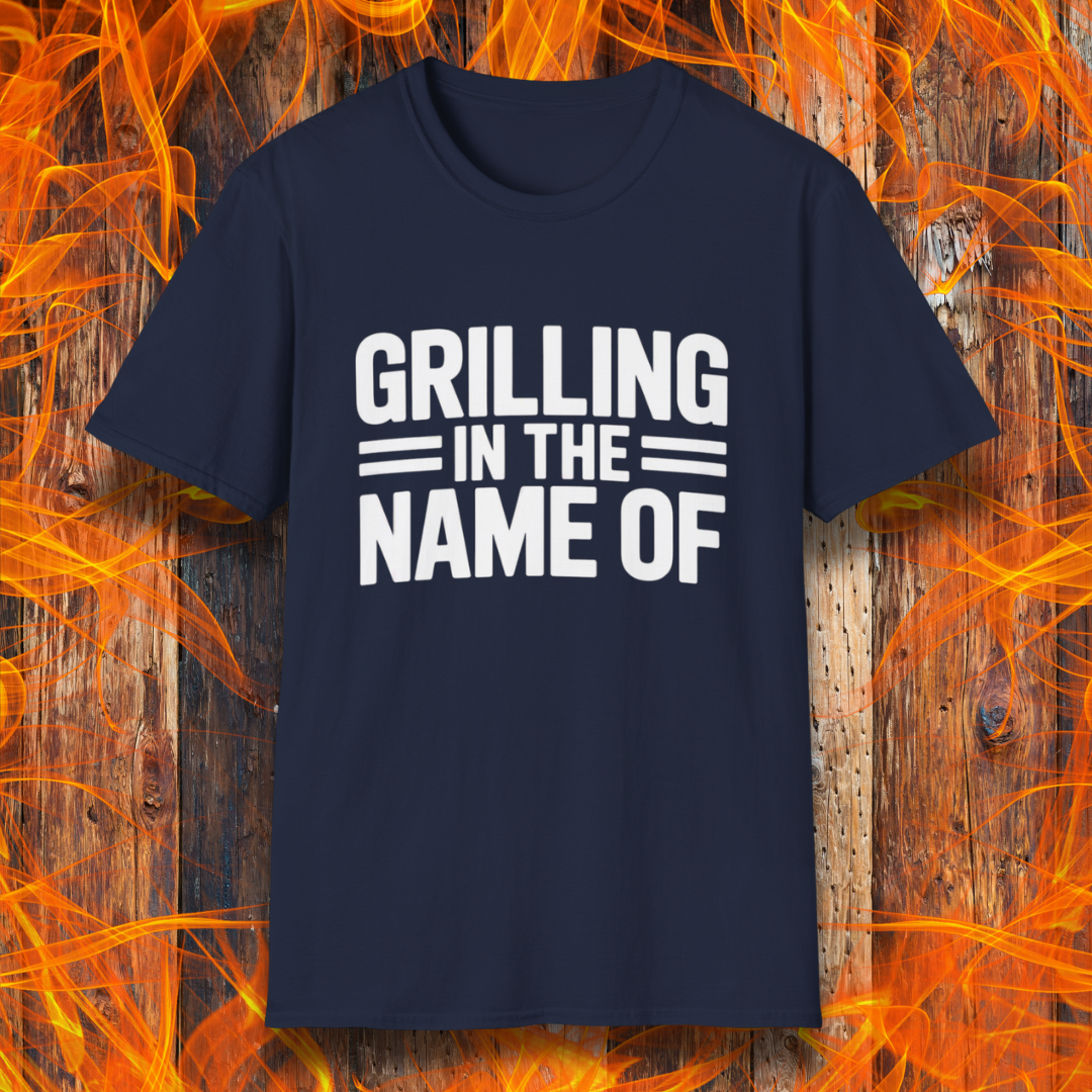 Navy T-shirt with bold white text that reads "Grilling in the Name Of" in a stacked, block-style font — a humorous BBQ-themed shirt for grilling enthusiasts.