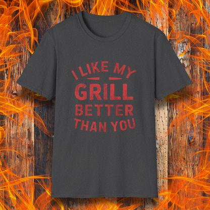Dark Heather T-shirt with a bold and humorous BBQ-themed design. The red distressed-style text reads 'I Like My Grill Better Than You' in an arched layout, perfect for grill masters who take their barbecue seriously. A fun and stylish shirt for BBQ enthusiasts."