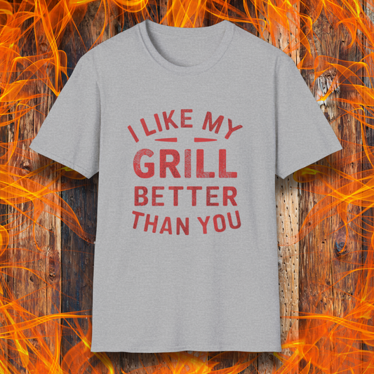 Sport Grey T-shirt with a bold and humorous BBQ-themed design. The red distressed-style text reads 'I Like My Grill Better Than You' in an arched layout, perfect for grill masters who take their barbecue seriously. A fun and stylish shirt for BBQ enthusiasts."