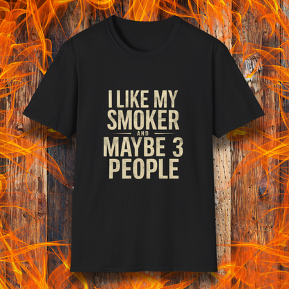 Black T-shirt featuring bold, distressed beige text that reads, 'I Like My Smoker And Maybe 3 People.' A humorous BBQ-themed shirt perfect for pitmasters and grilling enthusiasts who prefer the company of their smoker over most people!
