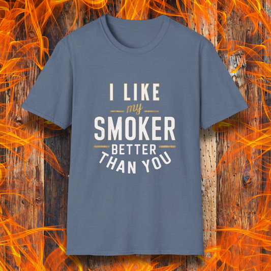 Heather Red  T-shirt featuring a witty BBQ-themed design. The bold text reads 'I Like My Smoker Better Than You' in a mix of white and gold lettering, with decorative lines adding emphasis. A perfect shirt for grill masters and smoking enthusiasts with a sense of humor.