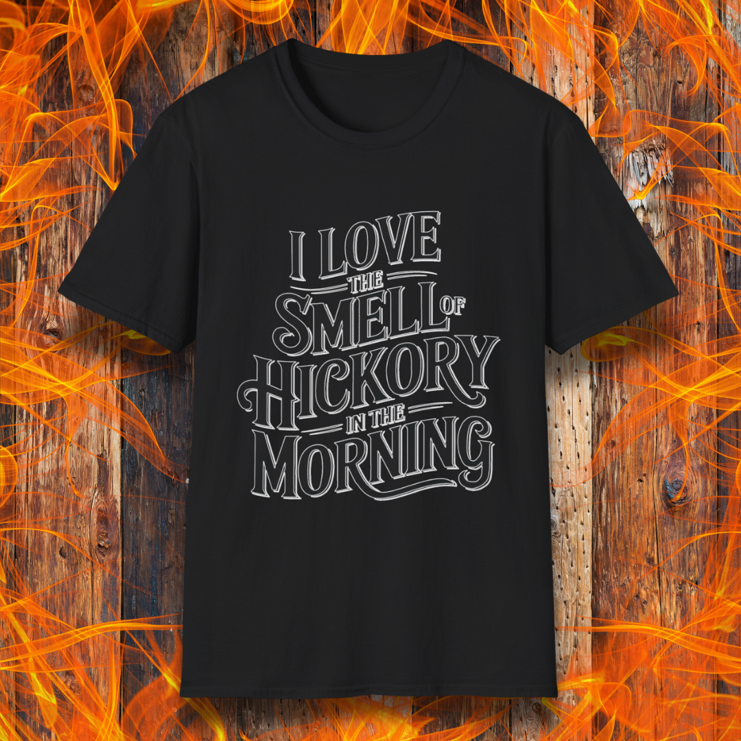 Black T-shirt featuring bold, vintage-style text that reads, "I Love the Smell of Hickory in the Morning." Perfect for BBQ enthusiasts who enjoy the aroma of smoked meat.