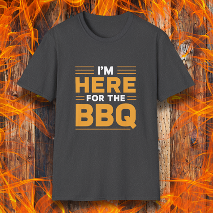 Dark Heather T-shirt with bold text reading 'I'M HERE FOR THE BBQ' in orange and white, accented with horizontal lines for emphasis. A stylish and fun design for BBQ lovers and grill masters.
