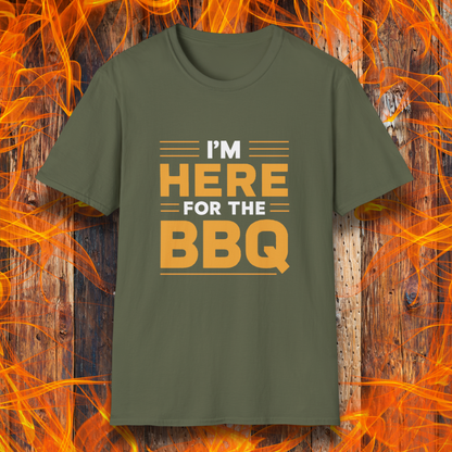 Military Green T-shirt with bold text reading 'I'M HERE FOR THE BBQ' in orange and white, accented with horizontal lines for emphasis. A stylish and fun design for BBQ lovers and grill masters.