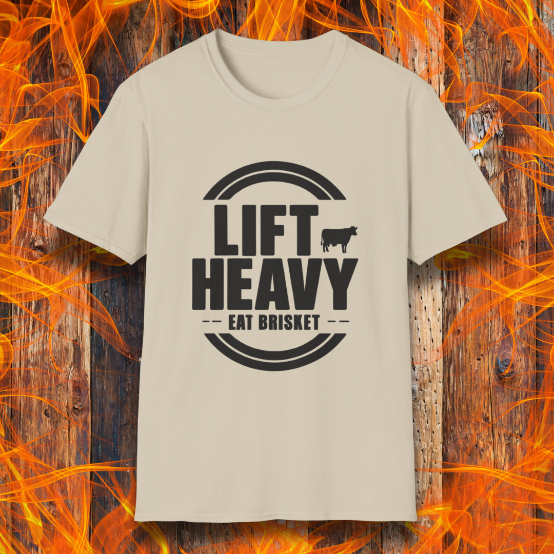 Sand colored T-shirt with "LIFT HEAVY EAT BRISKET" in bold text and a cow silhouette. Perfect for BBQ lovers, gym-goers, and meat-smoking enthusiasts.