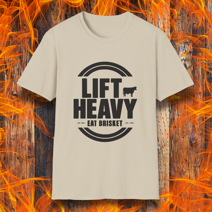 Sand colored T-shirt with "LIFT HEAVY EAT BRISKET" in bold text and a cow silhouette. Perfect for BBQ lovers, gym-goers, and meat-smoking enthusiasts.