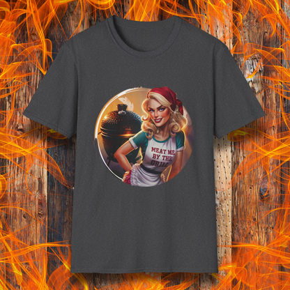 Dark Heather t-shirt featuring a vintage-inspired pin-up style woman in front of a charcoal grill, wearing an apron that reads 'Meat Me By The Grill.'"