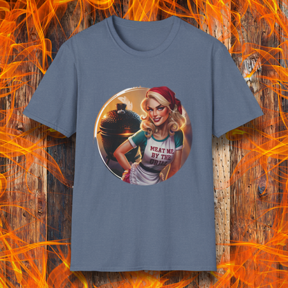 Heather Indigo t-shirt featuring a vintage-inspired pin-up style woman in front of a charcoal grill, wearing an apron that reads 'Meat Me By The Grill.