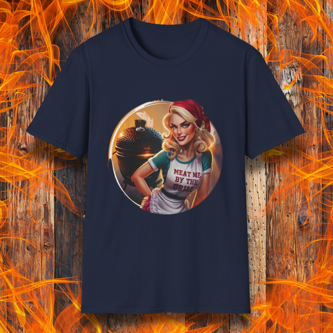 Navy t-shirt featuring a vintage-inspired pin-up style woman in front of a charcoal grill, wearing an apron that reads 'Meat Me By The Grill.