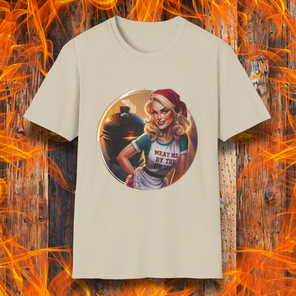 Sand t-shirt featuring a vintage-inspired pin-up style woman in front of a charcoal grill, wearing an apron that reads 'Meat Me By The Grill.