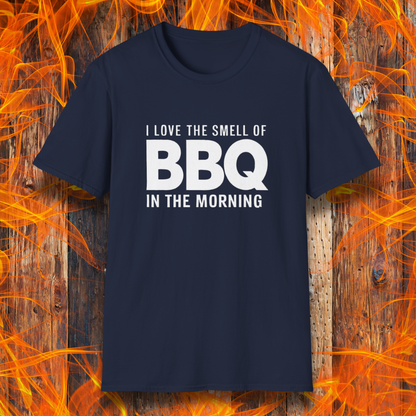 Navy t-shirt with the phrase 'I Love the Smell of BBQ in the Morning' in bold white text, displayed against a fiery wooden background
