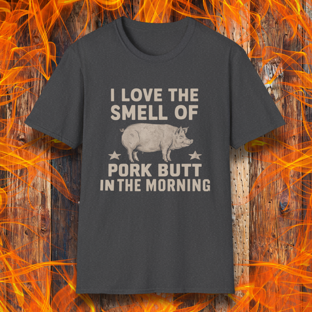 Dark Heather T-shirt with bold beige text reading 'I Love the Smell of Pork Butt in the Morning,' featuring a vintage-style pig illustration and star accents. Perfect for BBQ enthusiasts and pitmasters!
