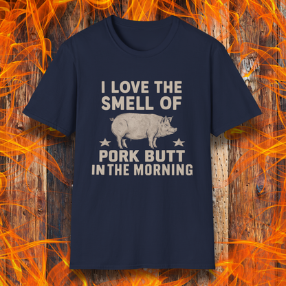 Navy T-shirt with bold beige text reading 'I Love the Smell of Pork Butt in the Morning,' featuring a vintage-style pig illustration and star accents. Perfect for BBQ enthusiasts and pitmasters!