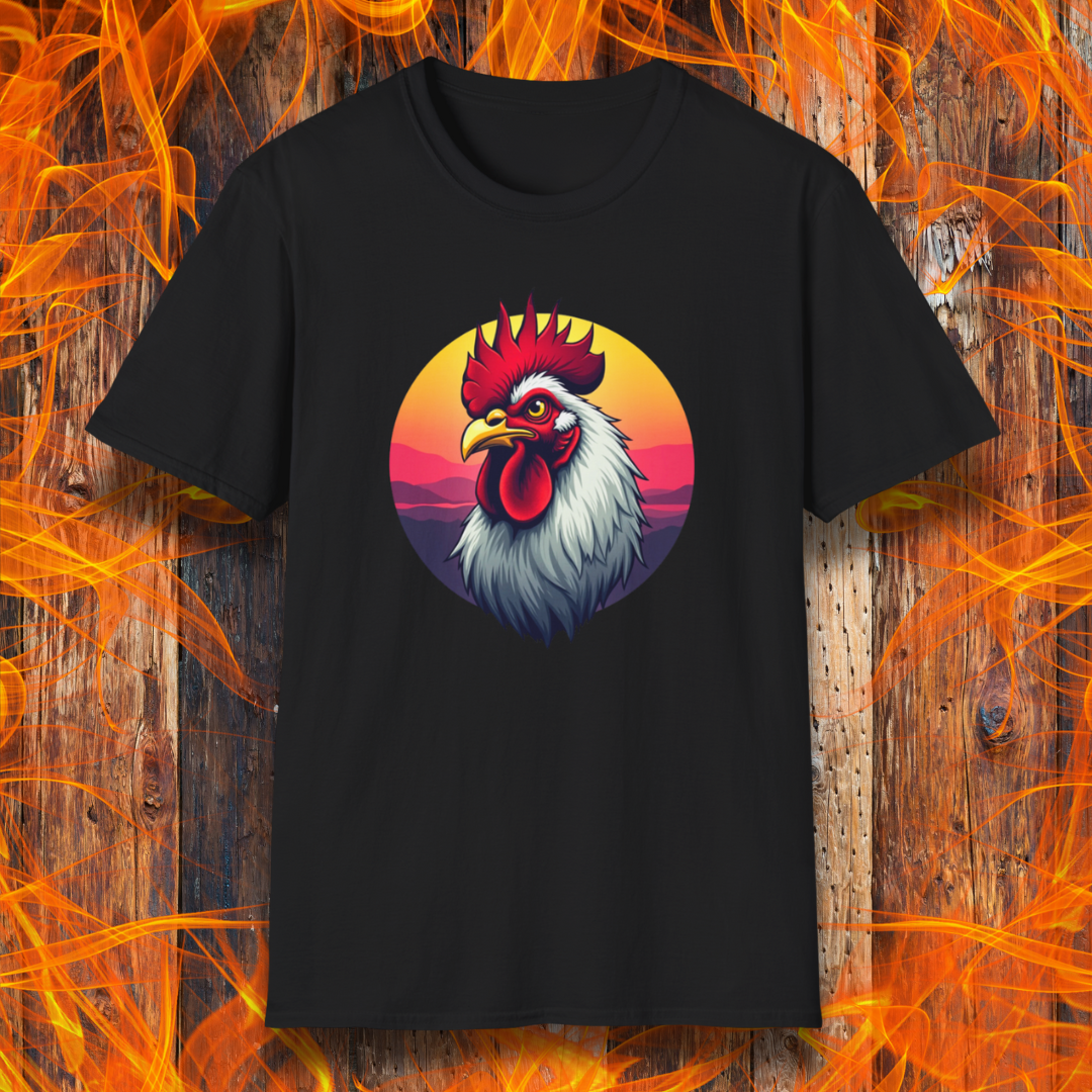 Black T-shirt featuring a bold and colorful illustration of a rooster with a dramatic red comb and white feathers, set against a circular sunset background with warm hues of orange, pink, and purple. The design exudes a rustic and vibrant aesthetic, perfect for BBQ and farm-style enthusiasts.