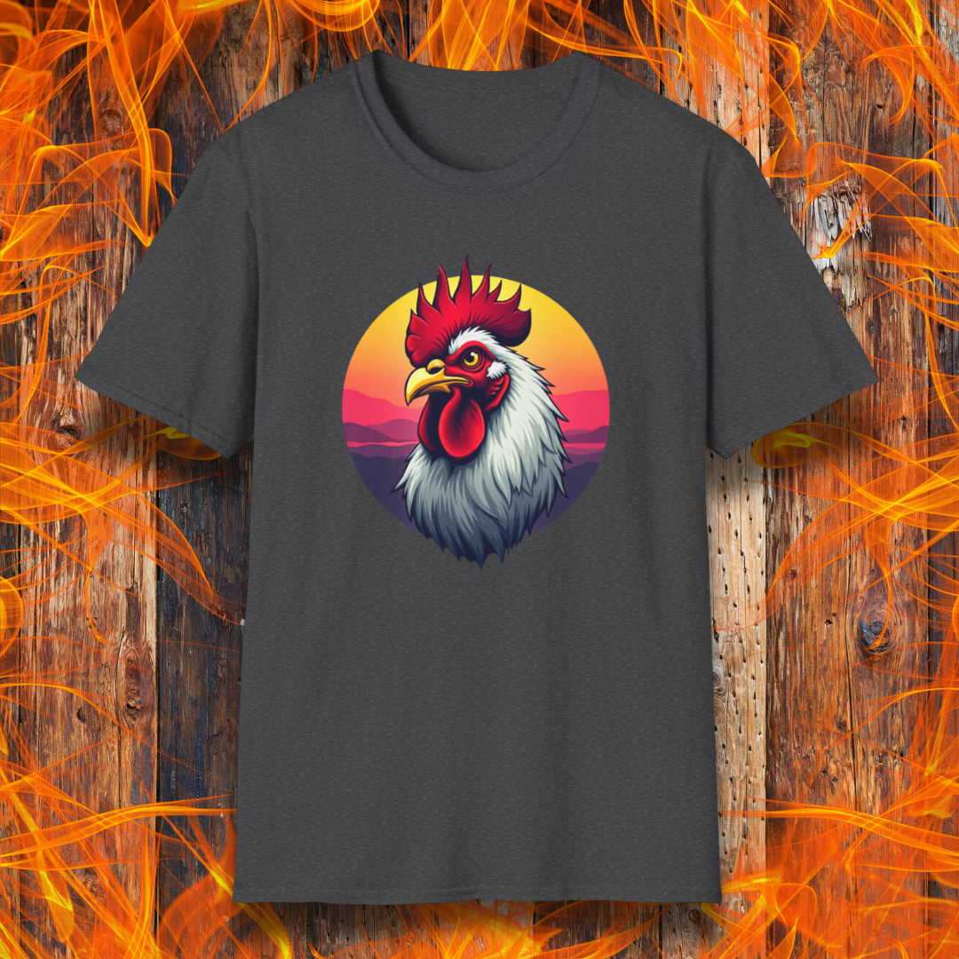 Dark Heather T-shirt featuring a bold and colorful illustration of a rooster with a dramatic red comb and white feathers, set against a circular sunset background with warm hues of orange, pink, and purple. The design exudes a rustic and vibrant aesthetic, perfect for BBQ and farm-style enthusiasts.