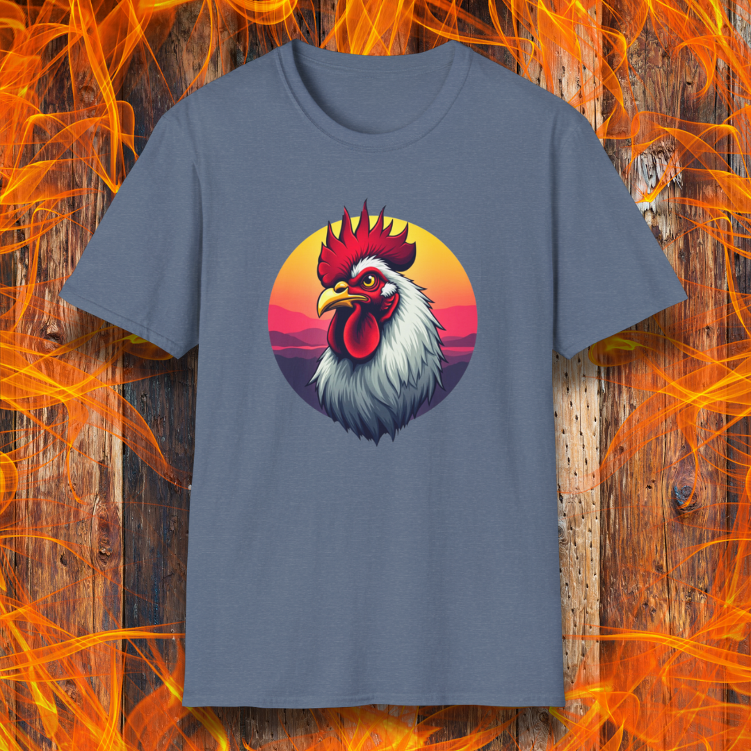 Heather Indigo T-shirt featuring a bold and colorful illustration of a rooster with a dramatic red comb and white feathers, set against a circular sunset background with warm hues of orange, pink, and purple. The design exudes a rustic and vibrant aesthetic, perfect for BBQ and farm-style enthusiasts.