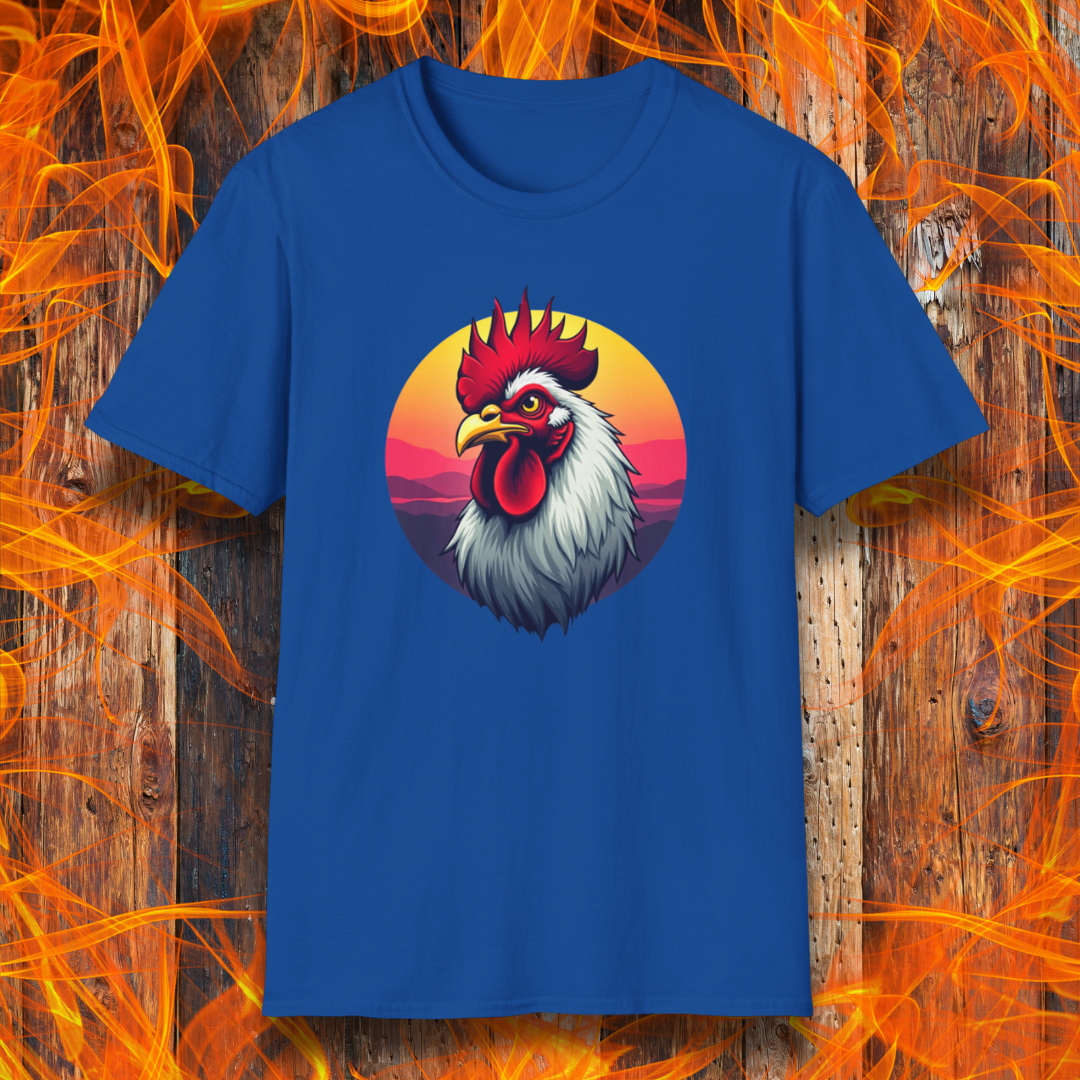 Royal Blue T-shirt featuring a bold and colorful illustration of a rooster with a dramatic red comb and white feathers, set against a circular sunset background with warm hues of orange, pink, and purple. The design exudes a rustic and vibrant aesthetic, perfect for BBQ and farm-style enthusiasts.
