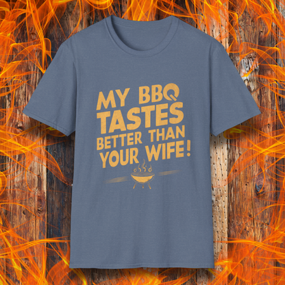 Heather Indigo T-shirt with a bold, cheeky design that reads 'MY BBQ TASTES BETTER THAN YOUR WIFE!' in vintage-style typography, featuring a small flaming grill icon. Perfect for grill masters with a sense of humor.