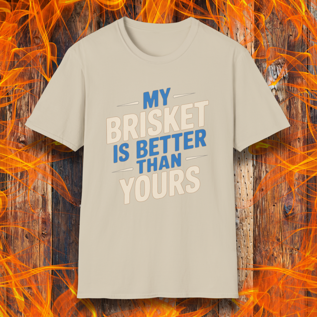 Sand T-shirt featuring a bold BBQ-themed design that reads 'MY BRISKET IS BETTER THAN YOURS' in cream and blue block lettering with accent lines. A perfect shirt for competitive grillers and brisket masters who love to show off their smoking skills.