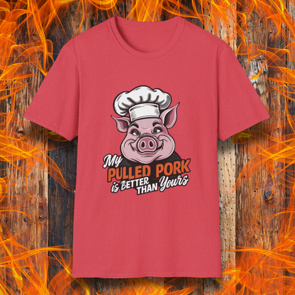 Heather Red T-shirt featuring a fun BBQ-themed design with a pink cartoon pig wearing a chef’s hat. The bold text reads 'My Pulled Pork is Better Than Yours' in a mix of white and red script and block lettering. Perfect for pitmasters who take pride in their slow-cooked pulled pork."