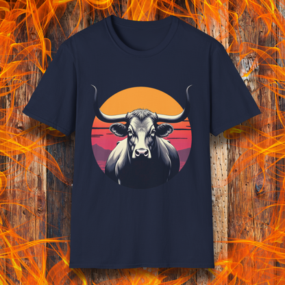 Navy T-shirt featuring a striking design of a longhorn bull staring forward with an intense gaze. The bull is set against a circular backdrop of a sunset with warm orange, red, and pink hues, along with silhouetted mountains in the background. The design conveys strength, confidence, and a bold Western aesthetic, appealing to BBQ and cattle enthusiasts.