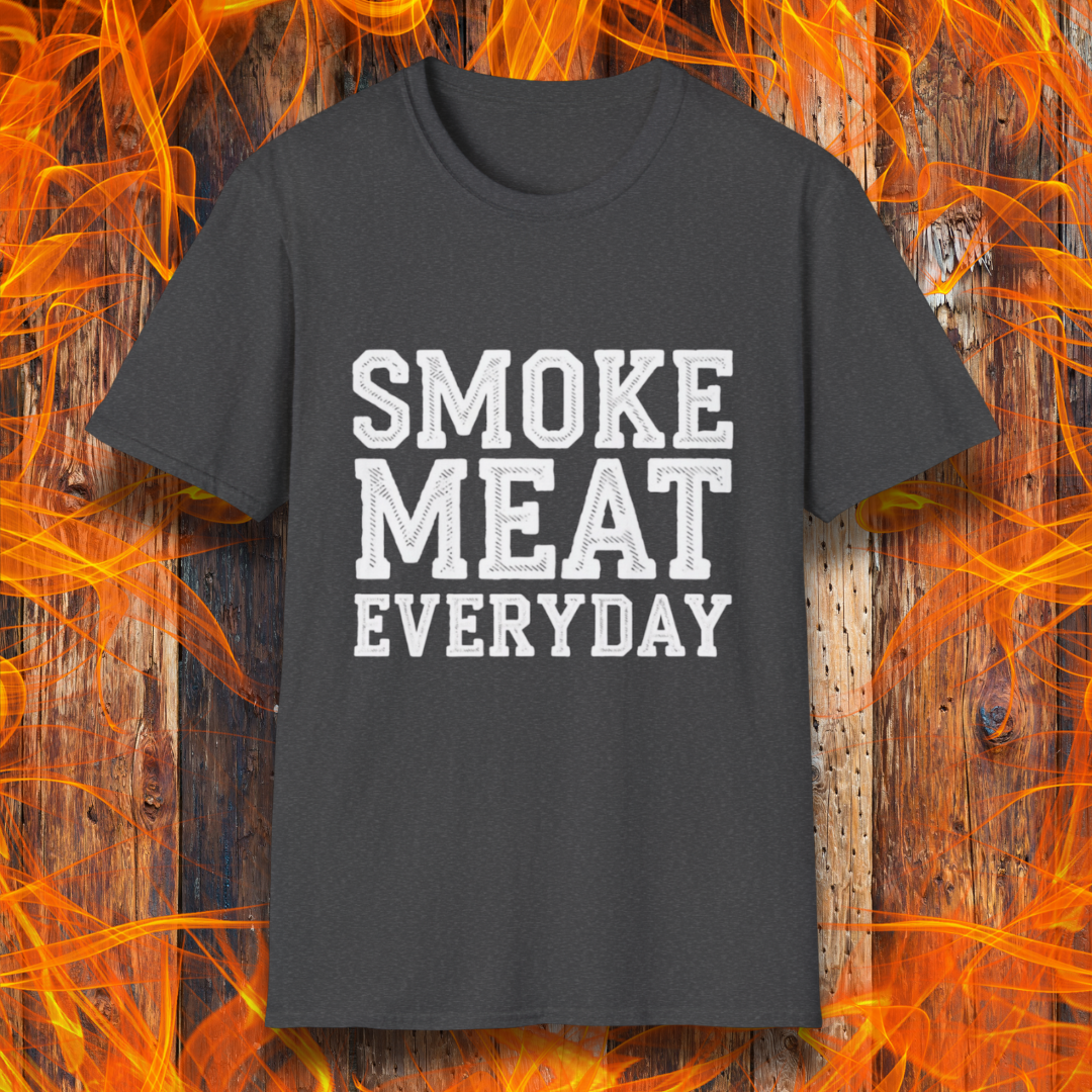 Dark Heather T-shirt featuring bold, white, distressed-text lettering that reads "SMOKE MEAT EVERYDAY." The shirt is displayed against a fiery wooden background, reinforcing the BBQ and grilling theme.