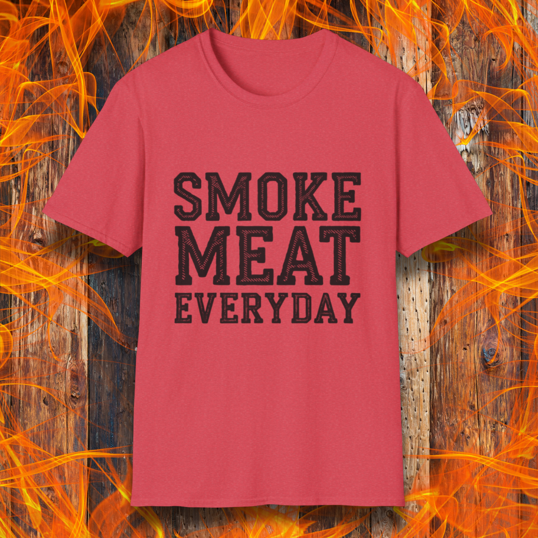 Heather Red T-shirt featuring bold, white, distressed-text lettering that reads "SMOKE MEAT EVERYDAY." The shirt is displayed against a fiery wooden background, reinforcing the BBQ and grilling theme.