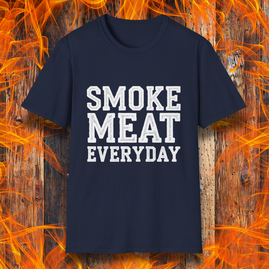 Navy T-shirt featuring bold, white, distressed-text lettering that reads "SMOKE MEAT EVERYDAY." The shirt is displayed against a fiery wooden background, reinforcing the BBQ and grilling theme.