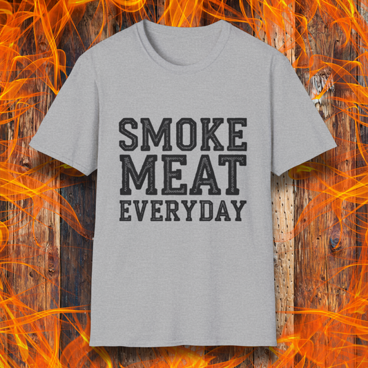Sport Grey T-shirt featuring bold, white, distressed-text lettering that reads "SMOKE MEAT EVERYDAY." The shirt is displayed against a fiery wooden background, reinforcing the BBQ and grilling theme.